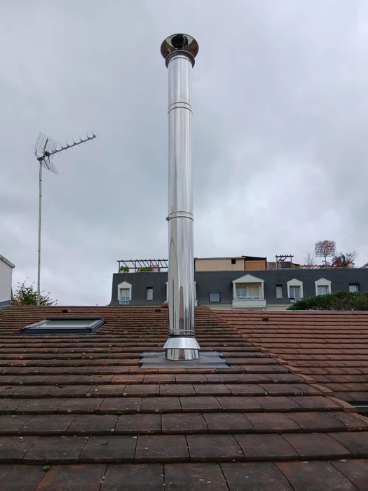 Toiture en tuiles terre cuite vue de face, conduit de fumée en inox double paroi installé en pied de toiture avec chapeau extracteur à rotule