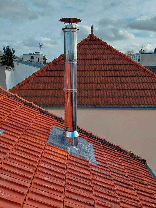 Toiture en tuiles rouges avec installation d'un conduit de fumée en acier inoxydable double paroi