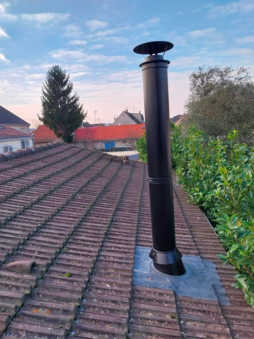 Façade extérieure d'un bâtiment résidentiel, installation d'un conduit de fumée en inox double paroi fixé en applique