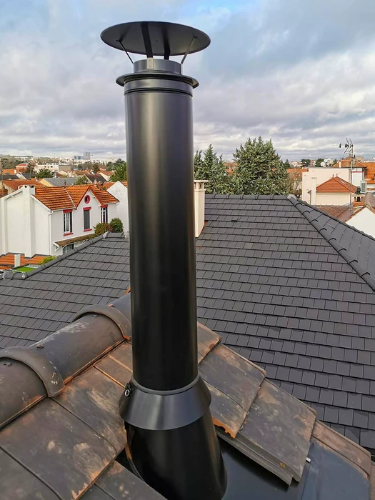 Façade extérieure d'un bâtiment résidentiel, installation d'un conduit de fumée en inox double paroi fixé en applique