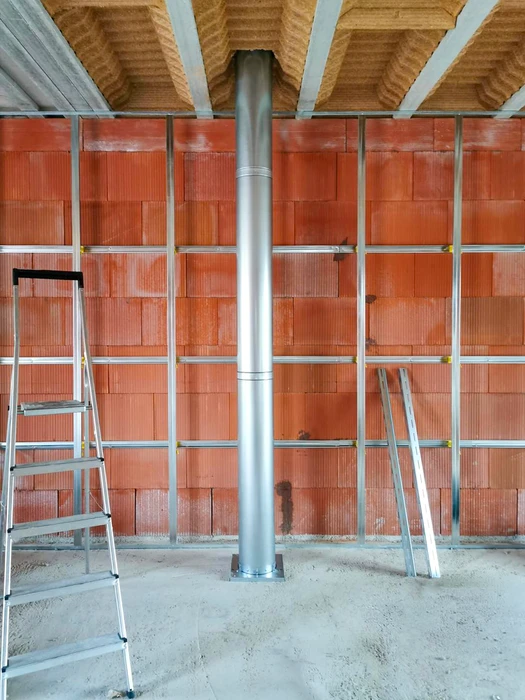 Façade extérieure d'un bâtiment résidentiel, installation d'un conduit de fumée en inox double paroi fixé en applique