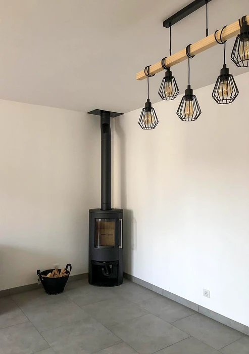 Façade extérieure d'un bâtiment résidentiel, installation d'un conduit de fumée en inox double paroi fixé en applique