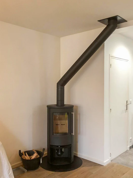 Façade extérieure d'un bâtiment résidentiel, installation d'un conduit de fumée en inox double paroi fixé en applique