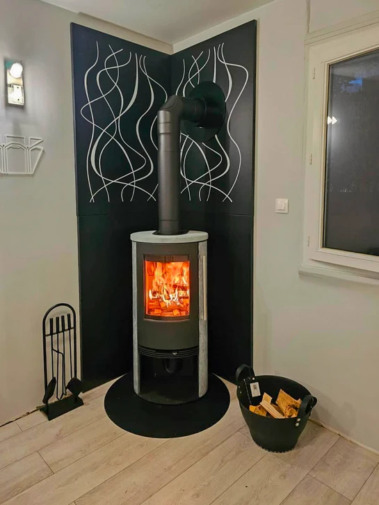 Intérieur moderne avec poêle à granulés en fonctionnement, flammes visibles dans le foyer vitré