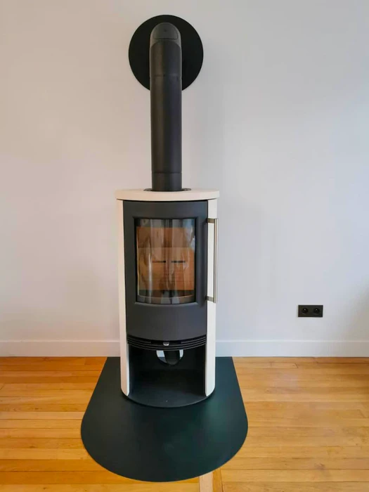 Poêle à bois design contemporain, carrosserie bicolore blanc et noir, vitre frontale avec feu actif visible, stockage de bûches intégré en partie basse