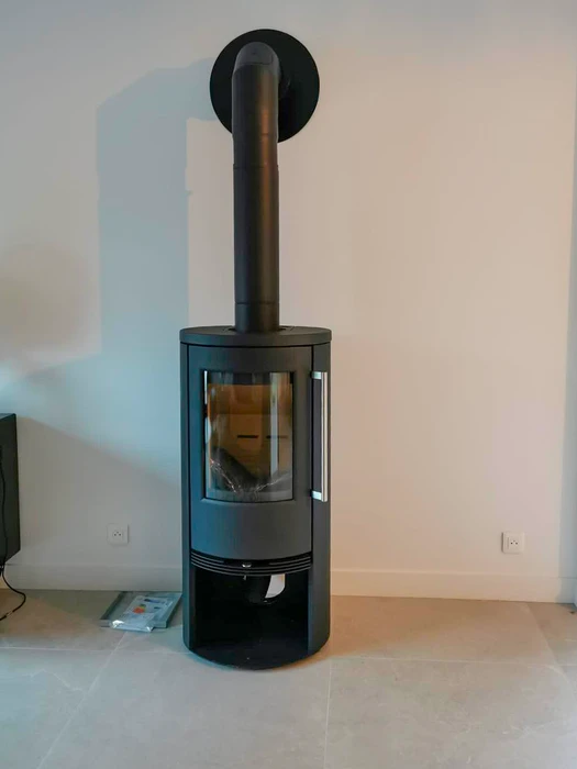 Poêle à bois design contemporain, carrosserie bicolore blanc et noir, vitre frontale avec feu actif visible, stockage de bûches intégré en partie basse