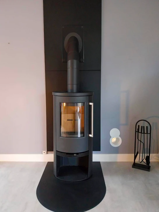 Intérieur résidentiel avec poêle à granulés moderne en fonctionnement, flammes visibles dans le foyer vitré