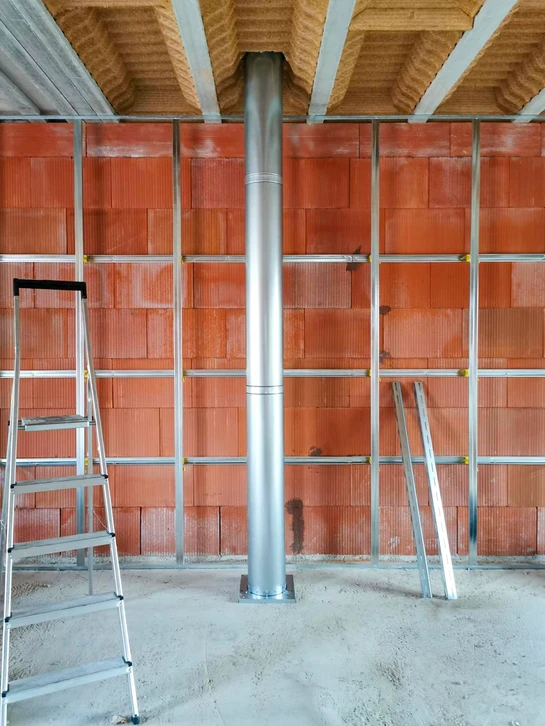 Ouvrier en équipement de sécurité installe une cheminée sur toiture en bardeaux d'asphalte