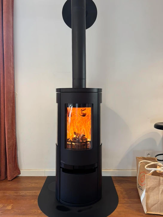 Deux ouvriers en casques bleus installent un conduit de cheminée sur une toiture en bardeaux d'asphalte