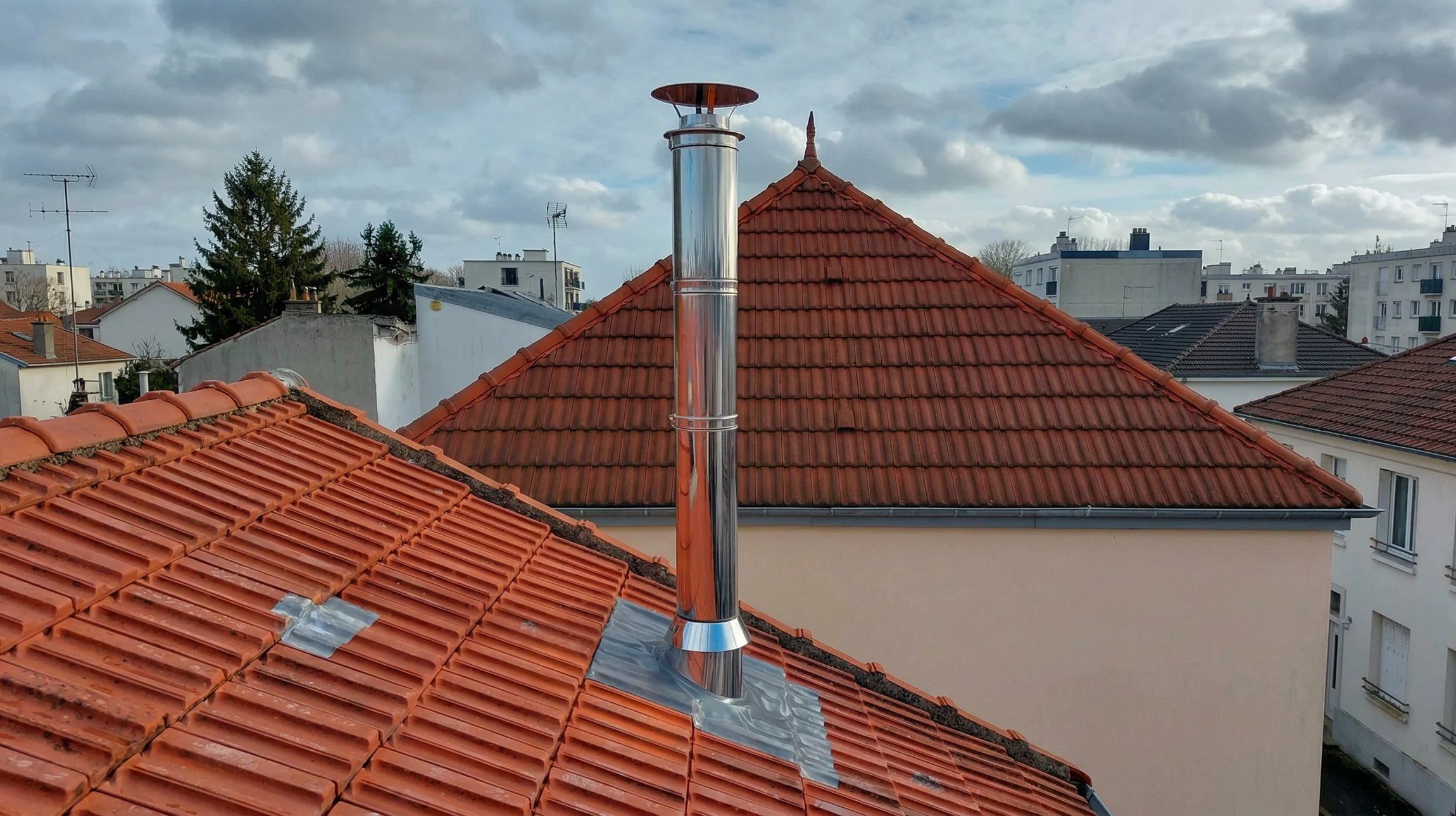 Intérieur avec mur de briques apparentes et conduit de cheminée en inox